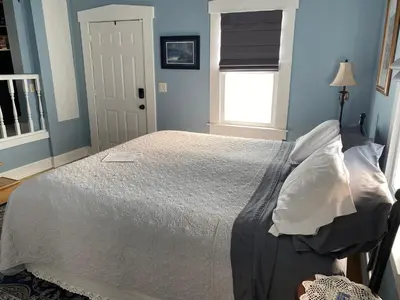 a bedroom with a bed with blue walls and a window at Iron Gate Inn in Madison