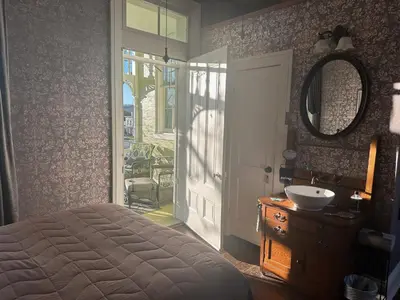 a bedroom with a bed and a sink and a mirror at Iron Gate Inn in Madison