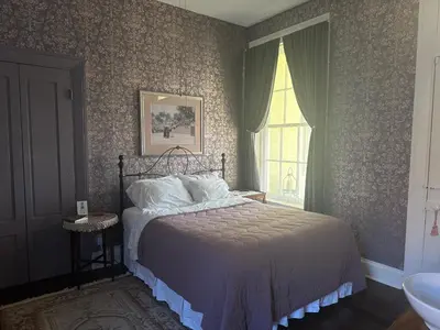 a bedroom with a bed and a window at Iron Gate Inn in Madison