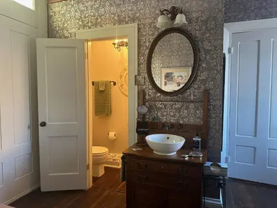 a bathroom with a sink and a toilet and a mirror at Iron Gate Inn in Madison
