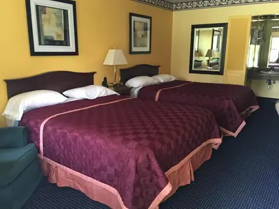 a hotel room with two beds and a couch at Norwalk Inn in Norwalk