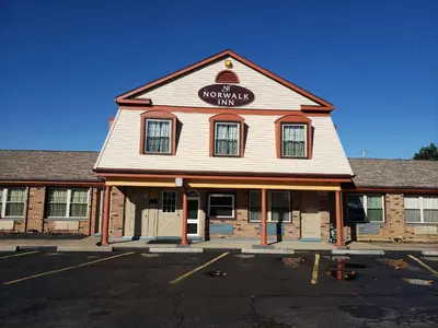 a brown and white building with a sign on it at Norwalk Inn in Norwalk