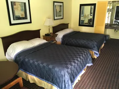 a hotel room with two beds and a table at Norwalk Inn in Norwalk