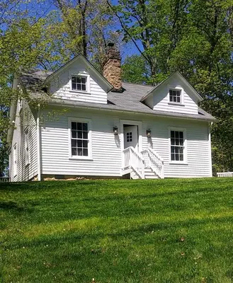 a white house on top of a green field at Historic Farmhouse by Nature Preserve in Charleston