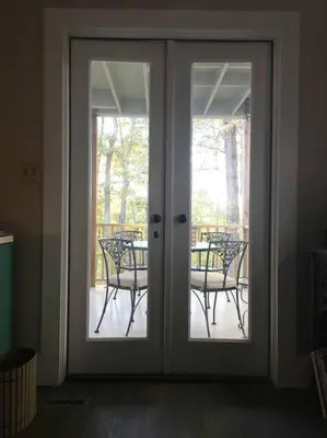 an open glass door with chairs on a patio at Historic Farmhouse by Nature Preserve in Charleston