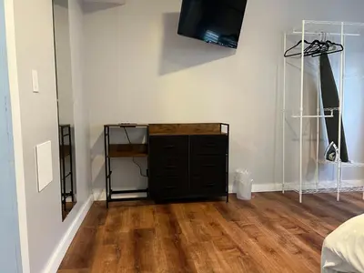 a bedroom with a dresser and a television on a wall at Stay with Jay - Quinta Suite in Cleveland