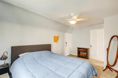 a bedroom with a blue bed and a ceiling fan at WFH-Friendly Abode with Home Gym in Cleveland in Cleveland