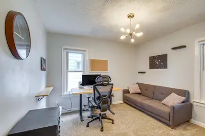 a living room with a couch and a desk with a computer at WFH-Friendly Abode with Home Gym in Cleveland in Cleveland