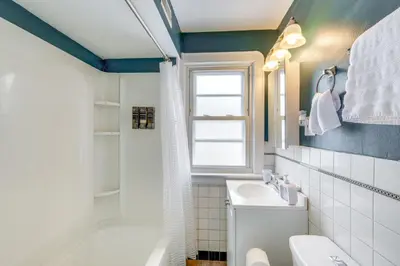 a bathroom with a sink and a toilet and a window at WFH-Friendly Abode with Home Gym in Cleveland in Cleveland