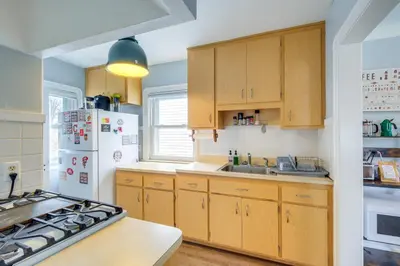 a kitchen with wooden cabinets and a white refrigerator at WFH-Friendly Abode with Home Gym in Cleveland in Cleveland