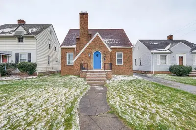 a house with a blue door and two white houses at WFH-Friendly Abode with Home Gym in Cleveland in Cleveland