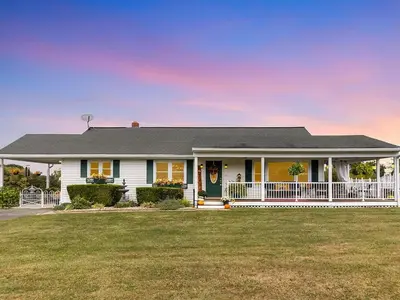 a white house with a white fence in a yard at Creation Resorts in Williamstown