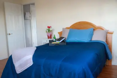 a bedroom with a blue bed with a table on it at Creation Resorts in Williamstown