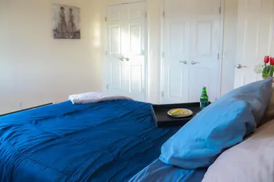 a blue bed in a bedroom with a table at Creation Resorts in Williamstown