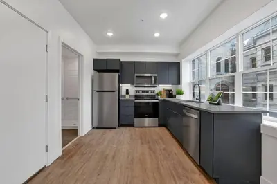 a large kitchen with stainless steel appliances and gray cabinets at Modern Apartment with Pool Table! Pet-friendly! in Columbus