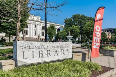 a sign for a library in front of a building at Modern Apartment with Pool Table! Pet-friendly! in Columbus