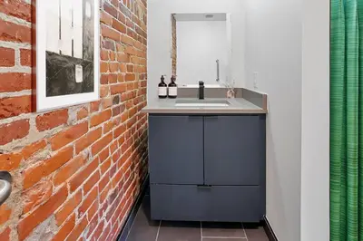 a bathroom with a sink and a brick wall at Modern Apartment with Pool Table! Pet-friendly! in Columbus