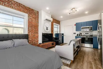 a bedroom with a bed and a brick wall at Central Loft with Pool Table! Pet-friendly Haven! in Columbus