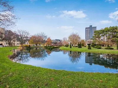 a pond in a park with a city in the background at Central Loft with Pool Table! Pet-friendly Haven! in Columbus