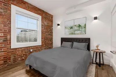 a bedroom with a bed and a brick wall at Designer 1-Bed Haven near Downtown! Pets Welcome! in Columbus