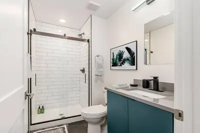 a bathroom with a toilet and a sink and a shower at Trendy Loft Escape with Pool Table Bring Your Pets in Columbus
