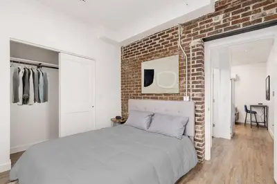 a bedroom with a bed and a brick wall at Oasis with Pool Table! Stylish Stay, Pets Allowed! in Columbus