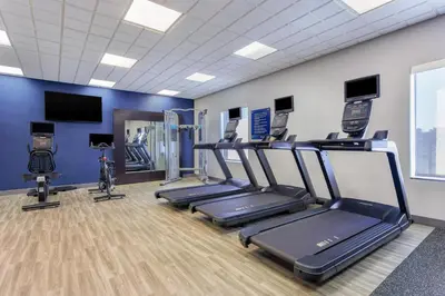 a gym with several treadmills and machines in a room at Hampton Inn and Suites Parkersburg Downtown in Parkersburg