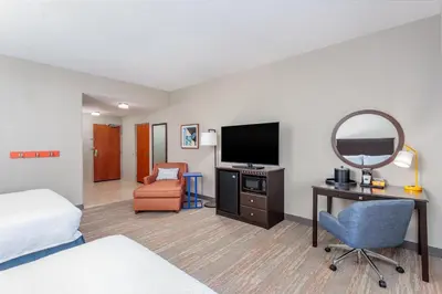 a hotel room with a bed a desk and a mirror at Hampton Inn and Suites Parkersburg Downtown in Parkersburg