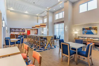 a dining room with tables and chairs and a cafeteria at Hampton Inn and Suites Parkersburg Downtown in Parkersburg