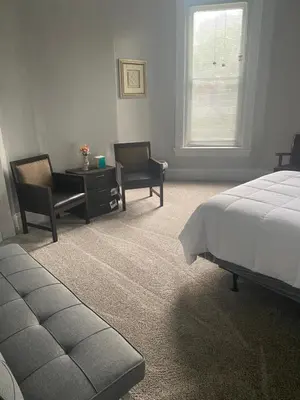 a bedroom with a bed and two chairs and a table at Walnut Hills Studio/ Private room in Cincinnati