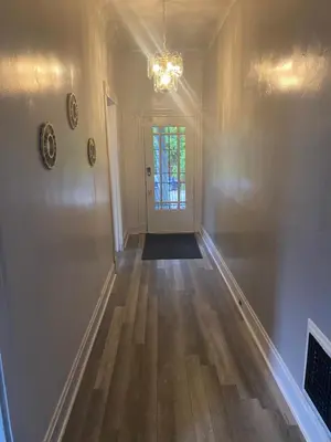an empty living room with a chandelier and wooden floors at Walnut Hills Studio/ Private room in Cincinnati