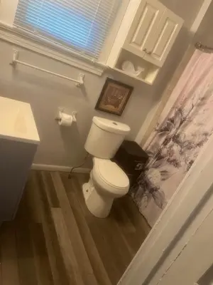 a bathroom with a toilet and a sink and a window at Walnut Hills Studio/ Private room in Cincinnati