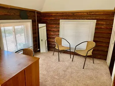 a dining room with a table and chairs in a room at Restored historic log cabin & deck on Lake Erie in Luna Pier