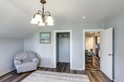 a living room with a chair and a chandelier at Greenwich Countryside Apartment with Shared Yard in Greenwich