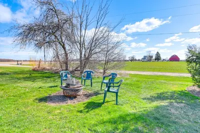 three blue chairs sitting in the grass in a field at Greenwich Countryside Apartment with Shared Yard in Greenwich