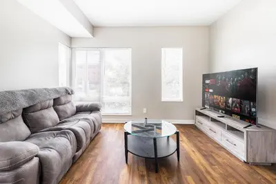 a living room with a couch and a flat screen tv at Luxury Downtown Townhome Unit 14 in Cleveland