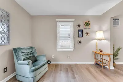 a living room with a blue chair and a table at Central Falls Hideaway in Cuyahoga Falls