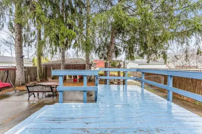 a blue bench sitting next to a wooden fence at Central Falls Hideaway in Cuyahoga Falls