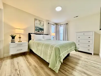 a bedroom with a bed and a dresser and a window at Beautiful NEW Ranch Home with a large deck and games in Maud