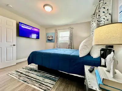a bedroom with a blue bed and a tv at New remodel exquisite master suite Trenton, Ohio in Trenton