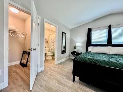 a bedroom with a green bed and a bathroom at New remodel exquisite master suite Trenton, Ohio in Trenton