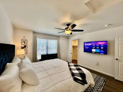 a bedroom with a bed with a ceiling fan and a tv at Pearl of a home, central Batesville, IN -New build in Batesville