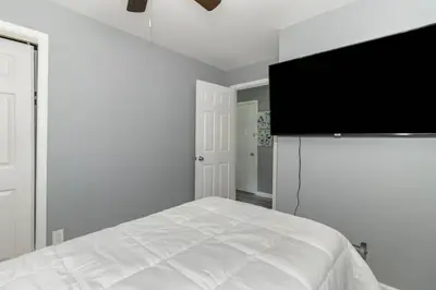 a bedroom with a bed and a flat screen tv at Furnished Ranch Home with FREE washer and dryer in Middletown