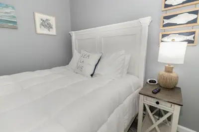 a bedroom with a white bed and a table with a lamp at Furnished Ranch Home with FREE washer and dryer in Middletown