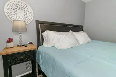 a bedroom with a bed and a table with a lamp at Furnished Ranch Home with FREE washer and dryer in Middletown