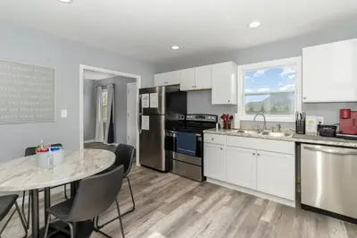 a kitchen with white cabinets and a table with chairs at Furnished Ranch Home with FREE washer and dryer in Middletown