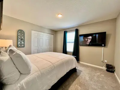 a bedroom with a bed and a tv on the wall at Brand new Executive home in Liberty Twp, Ohio in Maustown