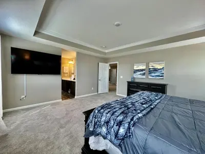 a bedroom with a large bed and a flat screen tv at Brand new Executive home in Liberty Twp, Ohio in Maustown