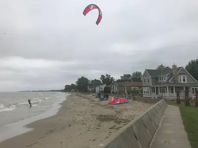 a person is flying a kite on the beach at Part of Mini-Mansion, private, 3 story Lake Erie views in Luna Pier