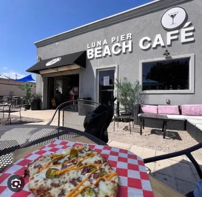 a pizza on a table in front of a beach cafe at Part of Mini-Mansion, private, 3 story Lake Erie views in Luna Pier